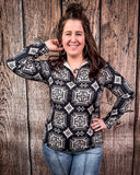 A model wearing the Down In The Hills Fitted Pullover with one hand on her hip and the other pulling back her hair in a wood back ground.