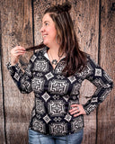 A model wearing the Down In The Hills Fitted Pullover with one hand on her hip and the other holding a piece of her hair while she looks to the left in a wood back ground.