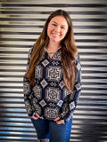 A model wearing the Down In The Hills Fitted Pullover in front of a metal panel.
