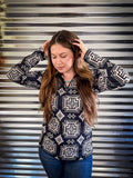 A model wearing the Down In The Hills Fitted Pullover while posing with both hands on her head.