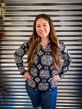 A model wearing the Down In The Hills Fitted Pullover with both hands on her hips in front of a metal panel.