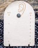 The Jamie Stud Fashion Earring on a measuring board, sitting on beans and wheat.