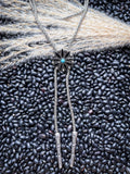 Southwestern bolo tie with silver beads and turquoise flower center styled flat lay