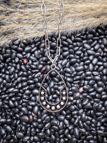Boho Western teardrop pendant necklace with silver beads styled on black beans and pampas