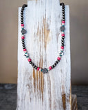 The Chance Navajo Style Pearl & Bead Necklace displayed on a wood plank.