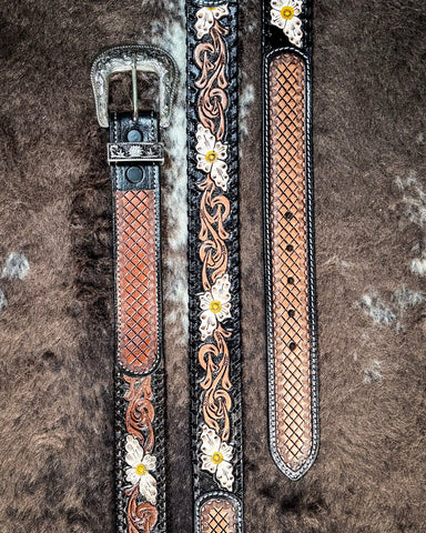 Decorative leather belt with floral and woven patterns on a textured brown background