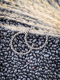 Earrings displayed on wheat and beans.