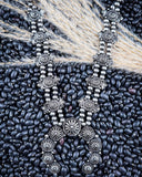 Necklace displayed on wheat and beans.