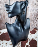 Earrings displayed on mannequin.
