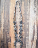 Necklace displayed on a ruler.