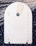 Sky and Stone Stud Fashion Earring on a ruler, displayed on beans and wheat.