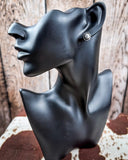 Sky and Stone Stud Fashion Earring Set on a mannequin, sitting on cowhide, wood back drop.