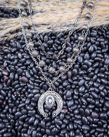 Three Trails Squash Blossom Fashion Necklace displayed on beans and wheat.