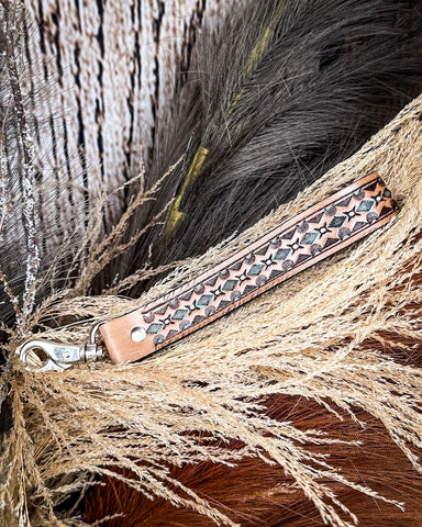 Canyon Spire Key Fob in Brown displayed on wheat, wood back drop.