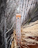 Canyon Spire Key Fob in Brown displayed on wheat, wood back drop.