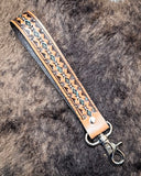 Canyon Spire Key Fob in Brown displayed on cowhide.