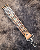Canyon Spire Key Fob in Brown displayed on cowhide.