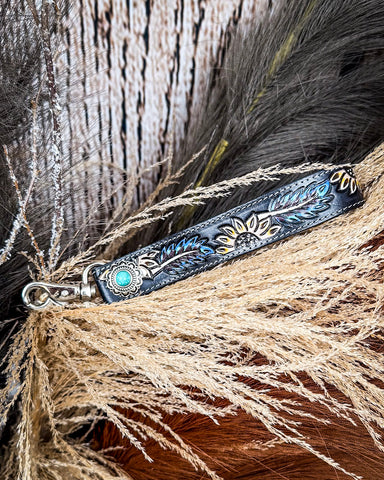 Cheyenne Bloom Hand-Tooled Key Fob displayed on wheat, wood back drop.