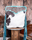 Back view of the Pony Trail Fringed Hand-Tooled Bag on a wood table with a wood back drop.