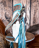 Side view of the Pony Trail Fringed Hand-Tooled Bag on a wood table with a wood back drop.