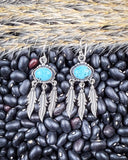 The Abey Genuine Turquoise Fringe Earrings displayed on beans and wheat.