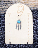 The Abey Genuine Turquoise Fringe Earrings displayed on a ruler, sitting on beans and wheat.
