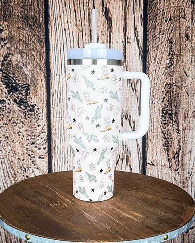 Boot and Blossom Tumbler displayed on wooden table in front off wooden background.