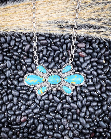 The Bullseye Fashion Necklace displayed on pebble and wheat background.