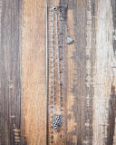 The Checkered Lightning Pendant Fashion Necklace displayed on wood background with ruler.