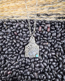 The Lightning Flush Pendant Fashion Necklace displayed on pebble and wheat background.