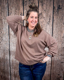 The Stillwater Tunic Top styled and modeled on a women in front of wood backdrop.