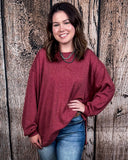 The Stillwater Tunic Top being styled  and modeled by women in front of wooden backdrop.