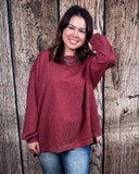 The Stillwater Tunic Top being styled  and modeled by women in front of wooden backdrop.