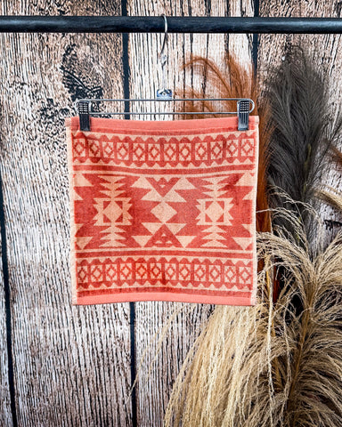 Navajo Adobe Towels displayed on rod in front of wood background.
