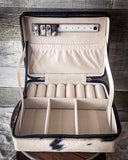 The inside of the Myra Bag - Mausoleum Jewelry Box to show the compartments. The box is sitting on a wood table with wood paneling in the back.
