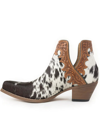 A single women's ankle boot with a black and white cowhide pattern, brown leather tooled details on the shaft, and a low brown block heel, shown from a side profile on a white background.