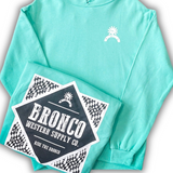 Close-up of folded bright teal Bronco hoodie featuring large back graphic and white chest logo
