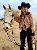 Woman wearing a tan mid-weight stretch suede button up with black trim and western swirl embroidery