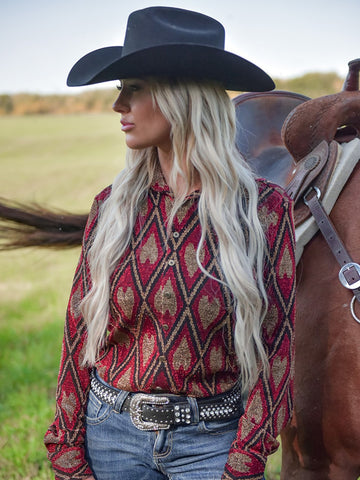 Woman wearing a red shimmer diamond print button up shirt with long sleeves