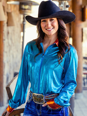 Woman wearing a turquoise metallic long sleeve zip top with rust accents