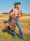 Woman wearing a rust metallic long sleeve button up shirt with colorful paisley trim