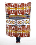 Patterned travel blanket with geometric and tribal design on a white background