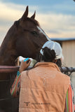 Woman standing in front of a horse wearing a boot stitch vest