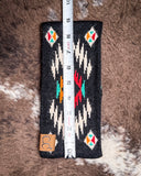 The Aztec Head Wrap, shown on a cowhide backdrop with a ruler indicating it measures about 9 inches long.
