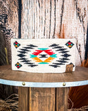 The Aztec Head Wrap displayed on a wooden table with wood in the background.