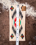 The Aztec Head Wrap, shown on a cowhide backdrop with a ruler indicating it measures about 9 inches long.