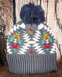 The back of the Aztec Pom Beanie on a wooden table with a white background.