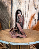 Side view of the Duskline Embossed Crossbody Purse displayed on a wooden table with wheat behind it, sitting in front of a wood back drop.