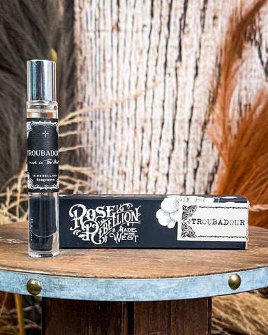Perfume displayed on wooden table.