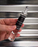 Perfume shown in front of metal background.